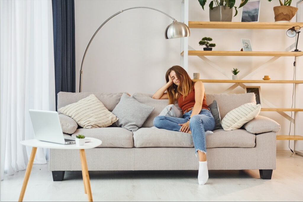 Photo of woman relaxing on the sofa in a peacefully decorated room.